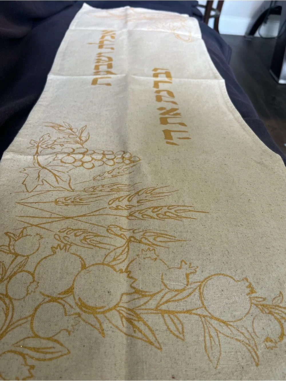 Gold and cream Shabbat tablecloth with gold Hebrew text and illustrations